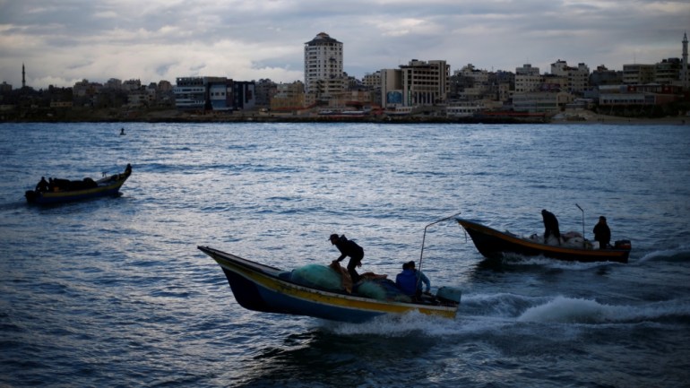 Palestinian fishermen ride boats at the seaport of Gaza City