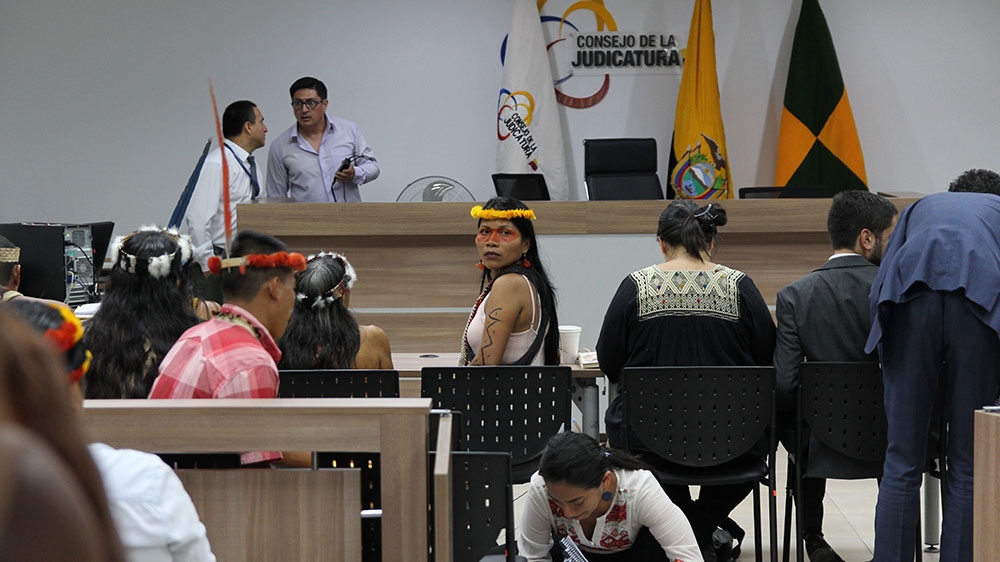 
Nemonte Nenquimo, one of the Waorani plaintiffs and representative of CONCONAWEP,sits in the courtroom waiting for the trial against the Ecuadorian government bodies to begin [Kimberley Brown/Al Jazeera]
