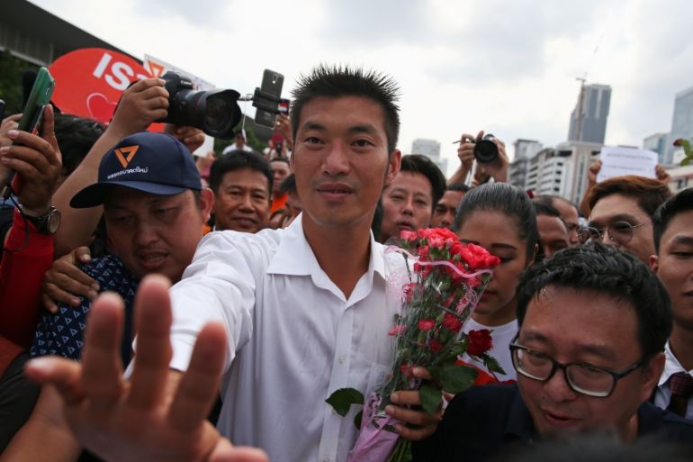 Thanathorn Juangroongruangkit, leader of the Future Forward Party, greets his supporters as he arrives at a police station to hear a sedition complaint filed by the army in Bangkok