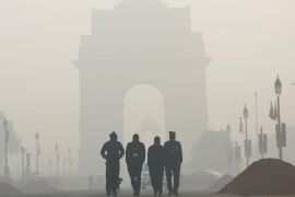 Men walk in front of the India Gate shrouded in smog in New Delhi
