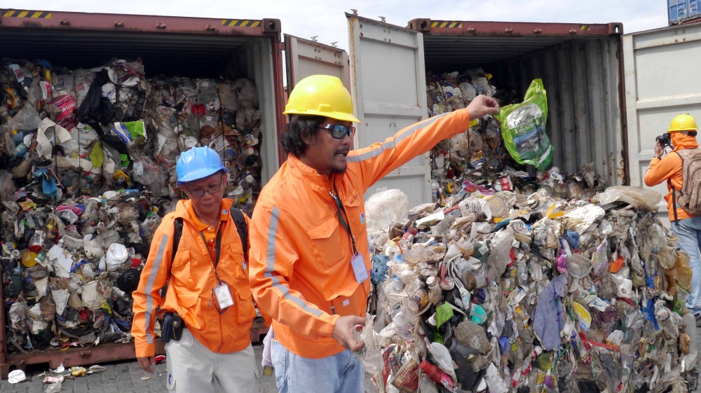 Philippine customs officials inspect cargo containers containing tonnes of garbage shipped by Canada at Manila port