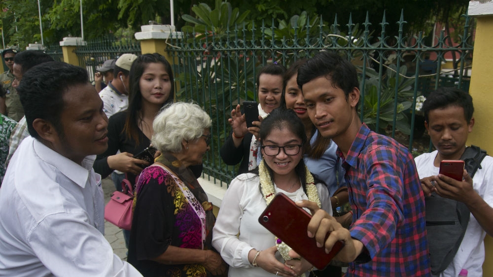 Popular opposition figure Sin Rozeth takes a selfie with a supporter after being interrogated for more than four hours by a provincial court in Battambang [Andrew Nachemson/Al Jazeera]