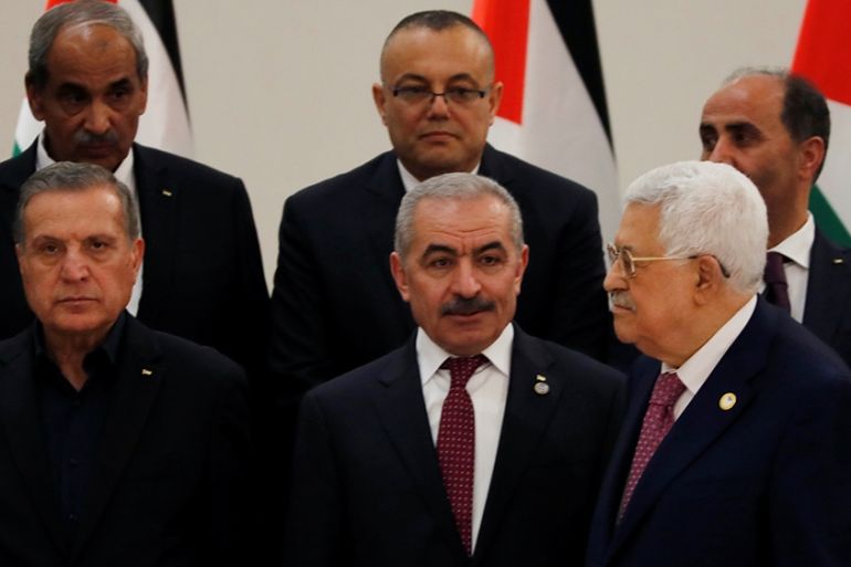 Palestinian President Mahmoud Abbas stands next to new Prime Minister Mohammad Shtayyeh and other members of the new government during a swearing in ceremony, in Ramallah in the Israeli-occupied West