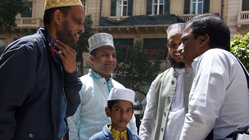 Imam Sehab Uddin (centre right) talks with other worshippers alongside his son Taki Abdullah (centre) [Savin Mattozzi/Al Jazeera]