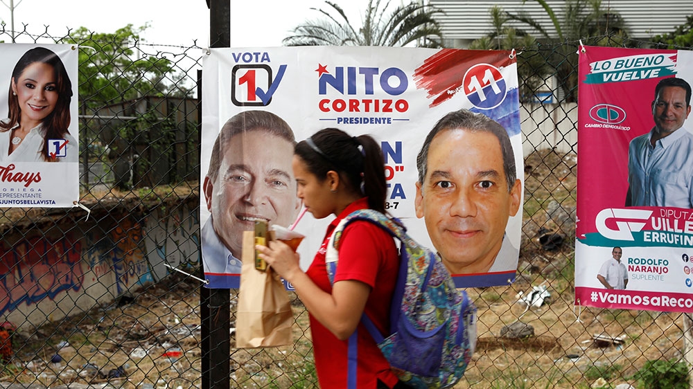 A woman walks next to posters of presidential candidate Laurentino Cortizo, of the PRD, before the general elections in Panama City [Carlos Jasso/Reuters] 