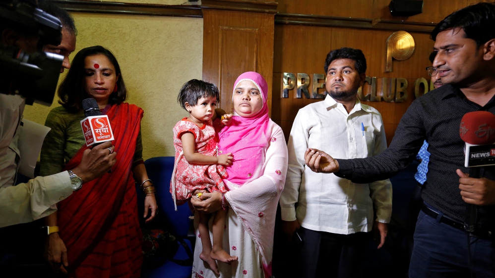 Bilkis Bano holds her daughter Aksha, as her husband looks on during a press conference in New Delhi, India May 8, 2017 [Cathal McNaughton/Reuters]