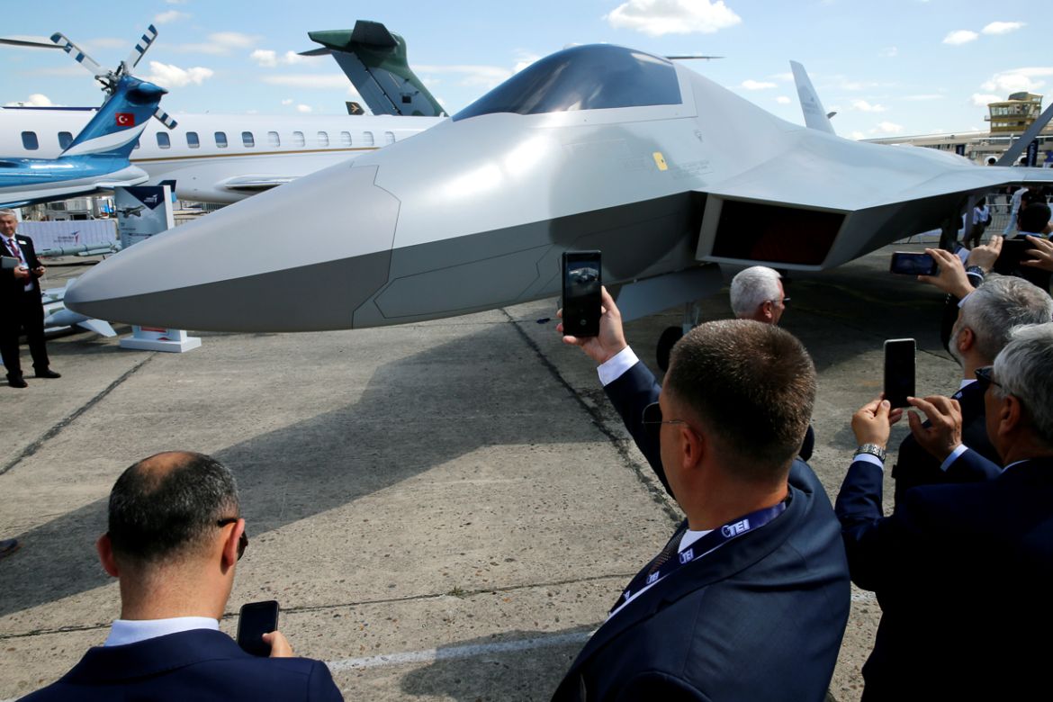 Visitors take pictures of the one-to-one mock-up of a Turkish fighter aircraft by Turkish Aerospace unveiled during the 53rd International Paris Air Show at Le Bourget Airport near Paris, France, June