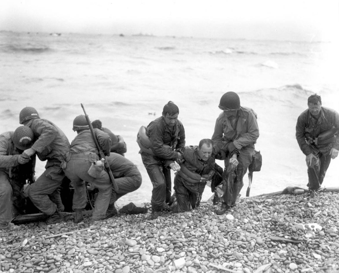 Members of an American landing party assist troops whose landing craft was sunk by enemy fire off Omaha beach, near Colleville sur Mer, France June 6, 1944 in this handout photo provided by the US Nat