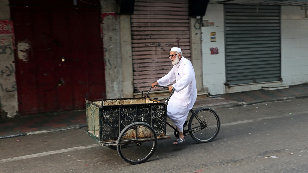 A man rides his bicycle cart past closed shops as Palestinians call for a general strike to protest against Bahrain's economic workshop for U.S. Middle East peace plan, in the southern Gaza Strip 