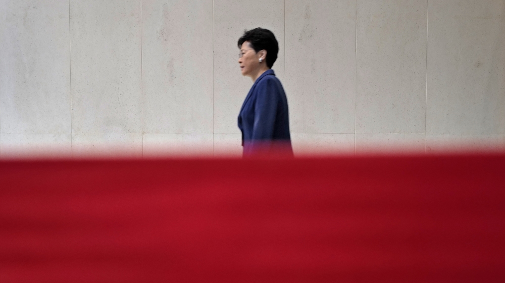 Hong Kong Chief Executive Carrie Lam walks behind a red barrier tape toward a press conference in Hong Kong Monday, June 10, 2019