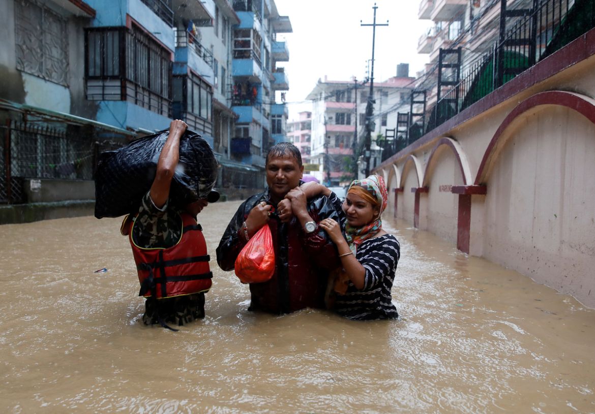 Residents walk towards dry ground from a flooded colony in Kathmandu, Nepal July 12, 2019. REUTERS/Navesh Chitrakar