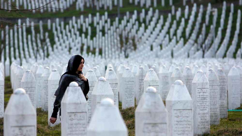 FILE - In this Sunday, March 20, 2016 file photo, a Bosnian woman walks among gravestones at Memorial Centre Potocari near Srebrenica, Bosnia and Herzegovina.