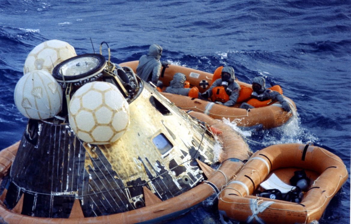 "US Navy members disinfect Apollo 11 astronauts Neil A Armstrong, Michael Collins And Edwin E Aldrin Jr after getting into the life raft during recovery operations after the completion of their succes