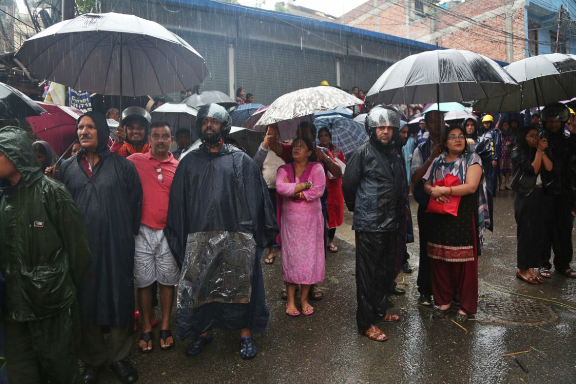 Nepalese people watch army man rescuing people from their flooded house in Kathmandu, Nepal, Friday, July 12, 2019.Heavy rainfall since Thursday night has caused havoc throughout the country. Accordin