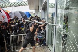 A protester is seen holding a steel pipe trying to break the glass outside Legco in Hong Kong, China. 1 July 2019. Hundreds of protesters gather outside trying to break the glass of Hong Kong''s mini-