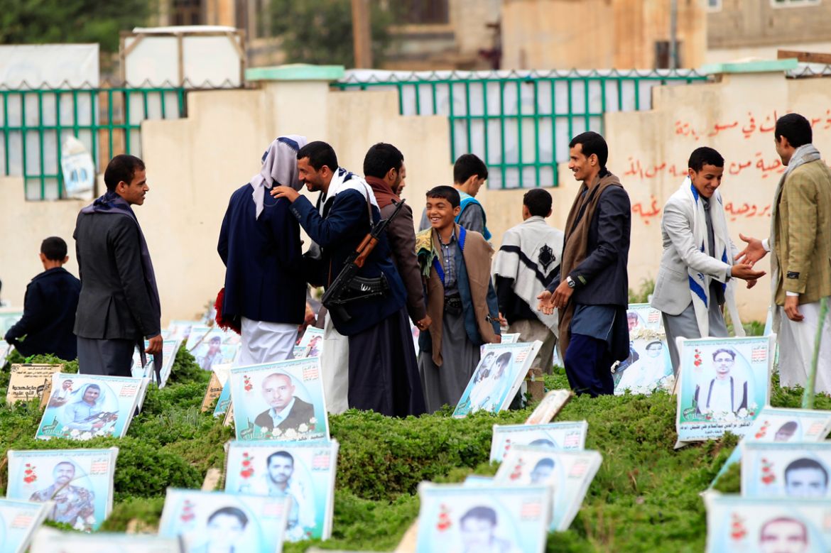 Yemeni men exchange wishes at a cemetary on the first day of the Eid al-Adha holiday in Yemen''s capital Sanaa on August 11, 2019, as Muslims across the world celebrated the first day of the Feast of S