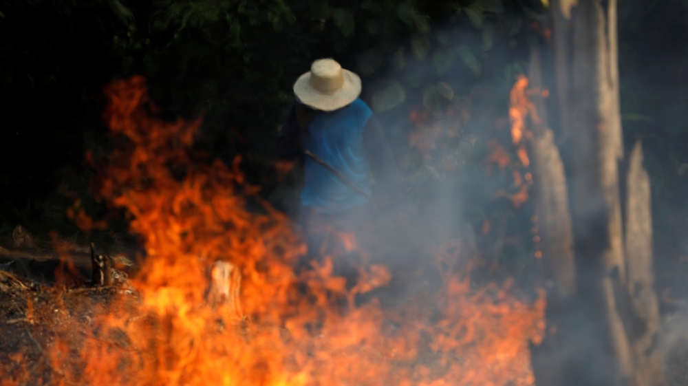 A man works in a burning tract of Amazon jungle as it is being cleared by loggers and farmers in Iranduba, Amazonas state, Brazil August 20, 2019