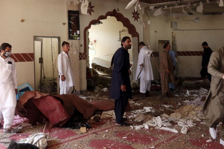 Members of a bomb disposal unit survey the site after a blast at a mosque in Kuchlak, in the outskirts of Quetta