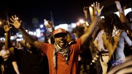 Demonstrators raise their arms as they protest against the shooting of Michael Brown in Ferguson, Missouri