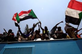 Sudanese civilians wave their national flags as they ride on the train to join in the celebrations of the signing of the Sudan''s power sharing deal, in Khartoum