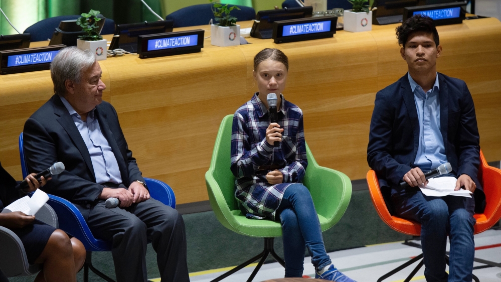 Swedish environmental activist Greta Thunberg, center, speaks to guests next to U.N. Secretary-General Antonio Guterres