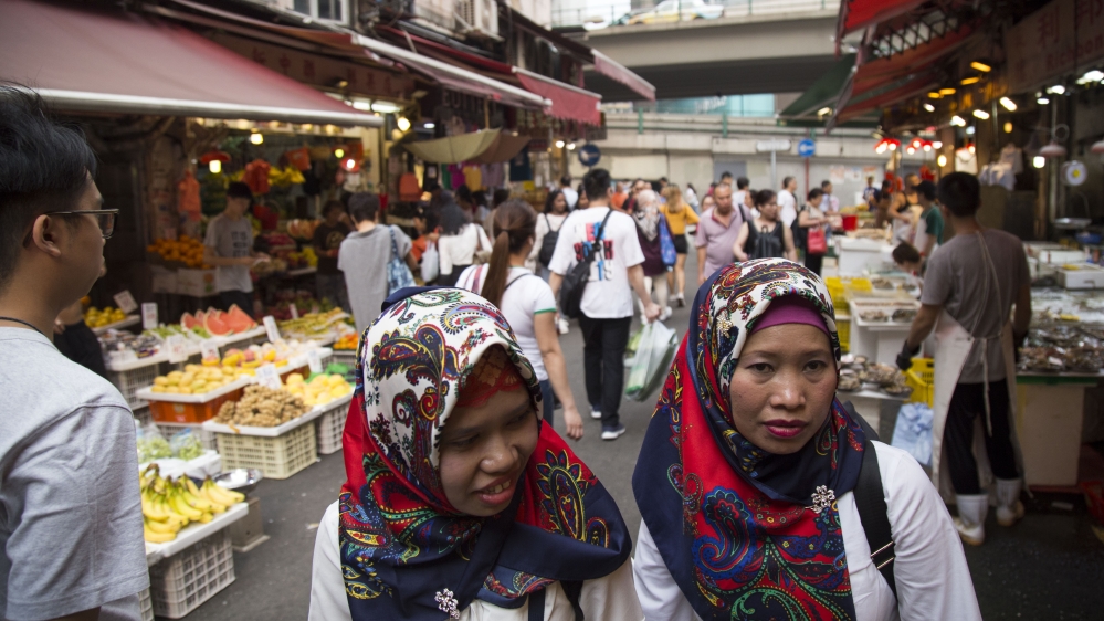 Women walk through a market off Bowrington Road, an area with numerous Indonesian-run businesses, blocks away from protest actions in Wan Chai on Sept. 30, 2019. 