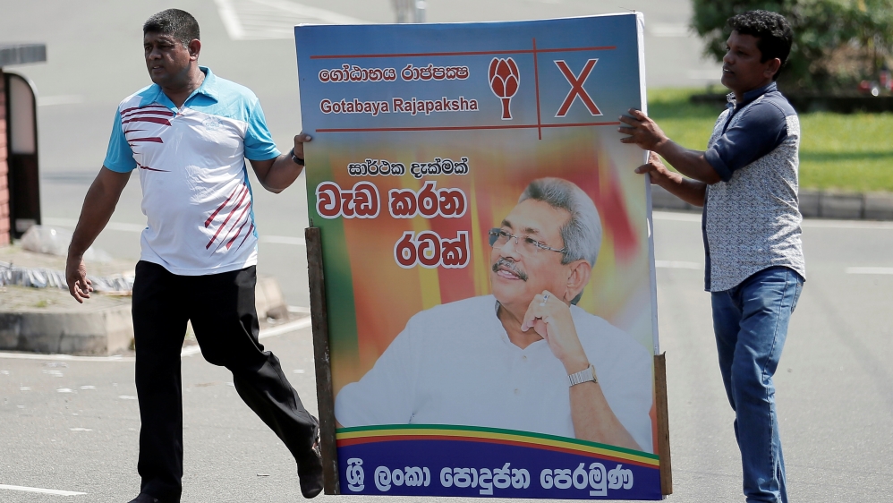 Supporters of Sri Lanka's President-elect Rajapaksa carry a poster of him in Colombo