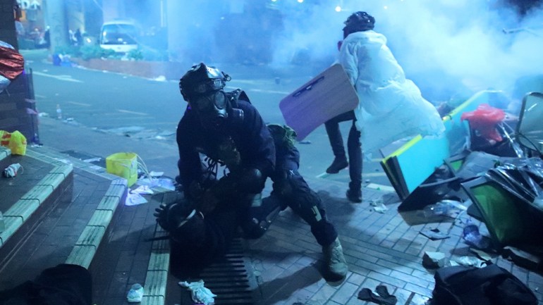 A policeman in riot gear detains a protester during Hong Kong protests.