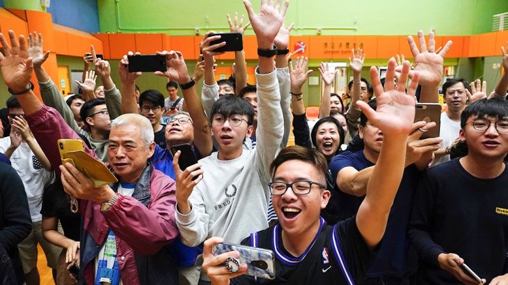 Supporters of pro-democracy candidate Angus Wong celebrate after he won in district council elections in Hong Kong, early Monday, Nov. 25, 2019. Vote counting was underway in Hong Kong early Monday af