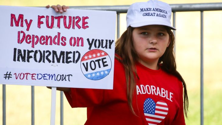 A girl holds up a sign at a conservative “Turn California Red” rally in Sacramento