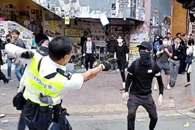 A still image from a social media video shows a police officer aiming his gun at a protester in Sai Wan Ho, Hong Kong, China November 11, 2019. CUPID PRODUCER via REUTERS