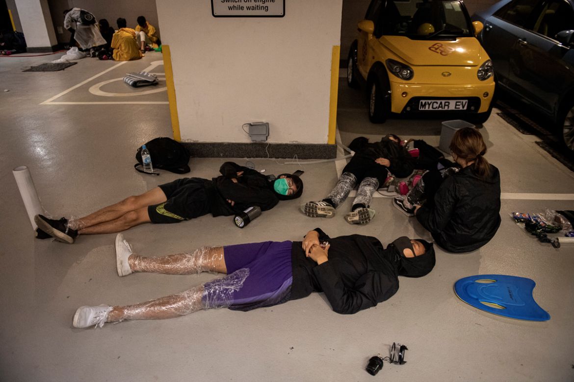Protesters sleep on the floor of a parking lot inside the Hong Kong Polytechnic University in the Hung Hom district of Hong Kong on November 20, 2019. - A dwindling number of exhausted pro-democracy p