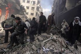 People walk on rubble as others try to put out a fire after what activists said were airstrikes followed by shelling by forces loyal to Syria''s President Bashar al-Assad in the Douma neighborhood of D