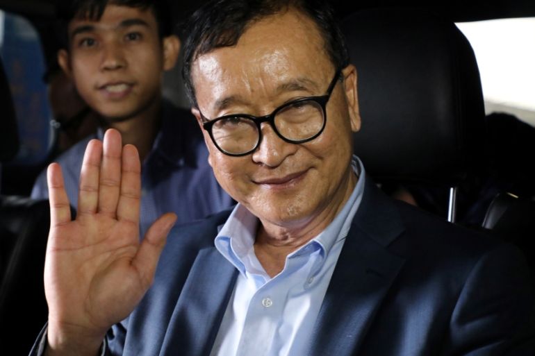 Cambodia''s self-exiled opposition party founder Sam Rainsy waves before he leaves Kuala Lumpur International Airport in Sepang