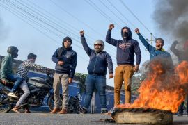 Protesters shout slogans as they burn tyres on a road during the strike called by North East Students'' Organization (NESO) against the government''s Citizenship Amendment Bill (CAB), in Guwahati on Dec