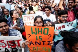 Students hold placards and shout slogans in solidarity with Jamia Millia Islamia university students after police entered the campus on the previous day in New Delhi, following a protest against a new