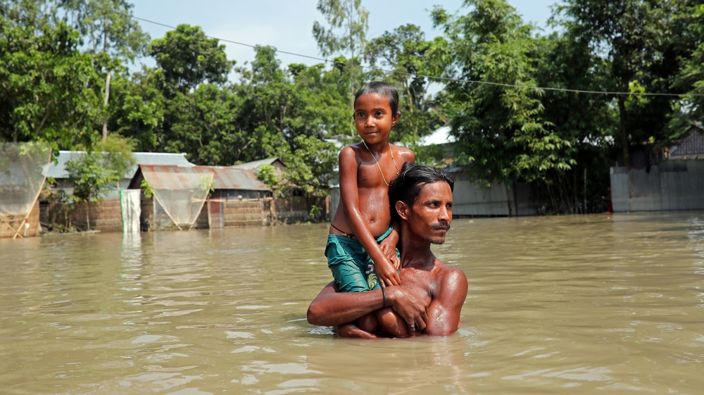Flood-affected people wade through flooded water in Jamalpur, Bangladesh, July 21, 2019. REUTERS/Mohammad Ponir Hossain
