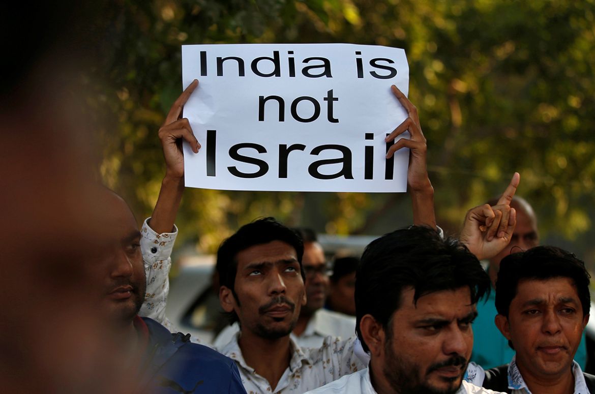 A demonstrator displays a placard during a protest against the Citizenship Amendment Bill, a bill that seeks to give citizenship to religious minorities persecuted in neighbouring Muslim countries, in