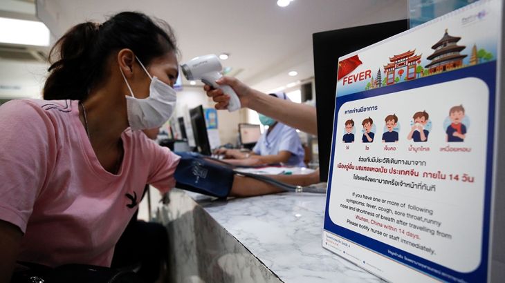A nurse checks a patient?s body temperature next to a campaign poster alerting on the coronavirus at a hospital in Bangkok, Thailand, 22 January 2020. The SARS-like coronavirus was detected in three C
