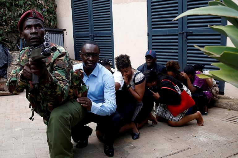 People are evacuated by a member of security forces at the scene where explosions and gunshots were heard at the Dusit hotel compound, in Nairobi, Kenya January 15, 2019. REUTERS/Baz Ratner