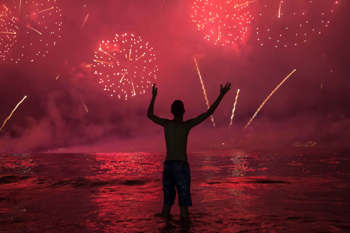 A man watches fireworks exploding over Copacabana Beach during the New Year''s celebrations, in Rio de Janeiro, Brazil, Wednesday, Jan. 1, 2020. (AP Photo/Bruna Prado)