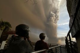 People watch from Tagaytay, Cavite province as Taal Volcano erupts Sunday Jan. 12, 2020. (AP Photo/Aaron Favila)