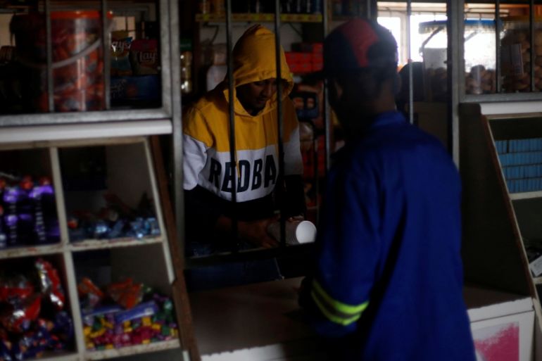 Shopkeeper serves a customer during an electricity load-shedding blackout in Hillcrest