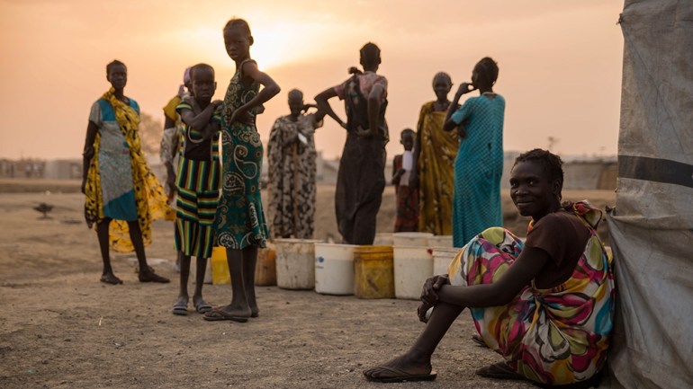 Women exchange distributed food in the early morning at the Protection of Civilian site (PoC) in Bentiu, South Sudan, on February 15, 2018. - Bentiu''s Protection of Civilian site was established in Ja