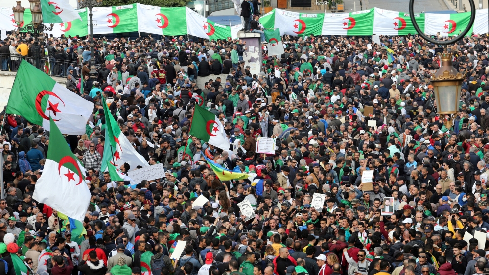 Demonstrators carry flags and banners during an anti-government protest in Algiers