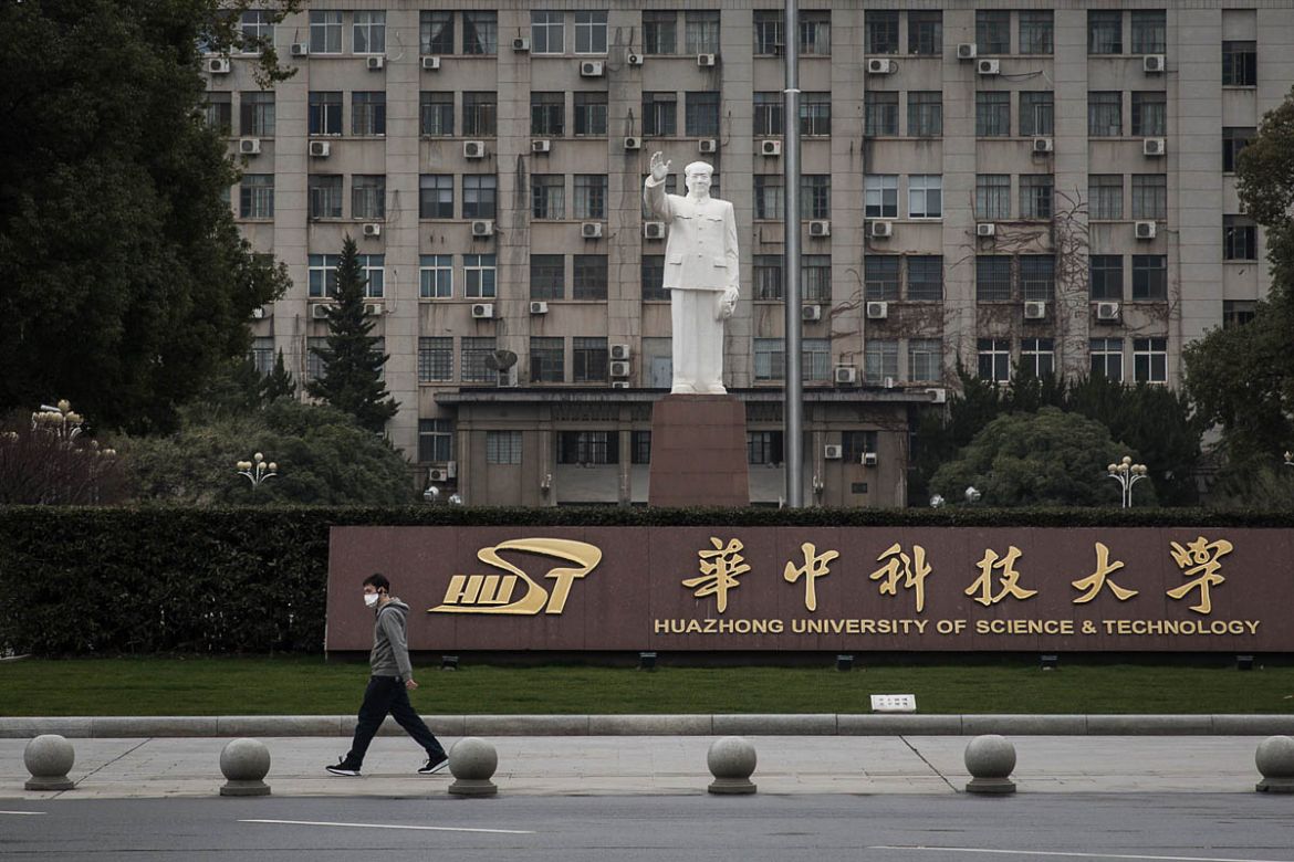 WUHAN, CHINA - FEBRUARY 07: A man passes by the statue of Mao Zedong in Huazhong University of Science and Technology on February 7, 2020 in Wuhan, Hubei province, China. The number of those who have