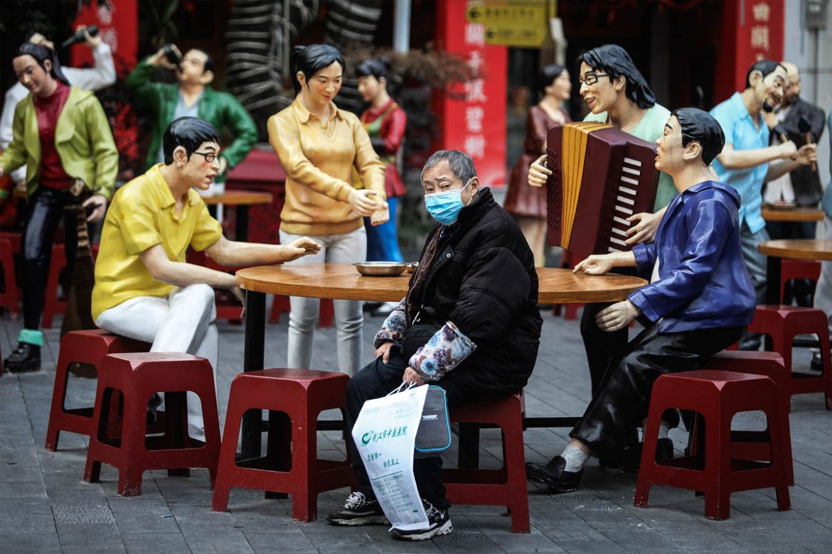 WUHAN, CHINA - FEBRUARY 08: (CHINA OUT) A patient sits nearby to a sculpture in a traditional food culture street on February 8, 2020 in Wuhan, Hubei province, China. The number of those who have di
