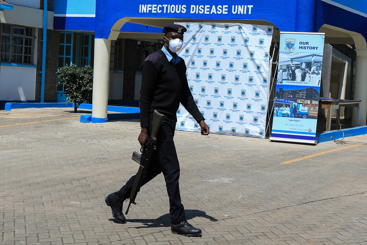 epa08295591 A Kenyan police officer wearing a face mask patrols within the newly constructed Infectious Disease Unit, that is currently holding 22 people who are under quarantine believed to have had