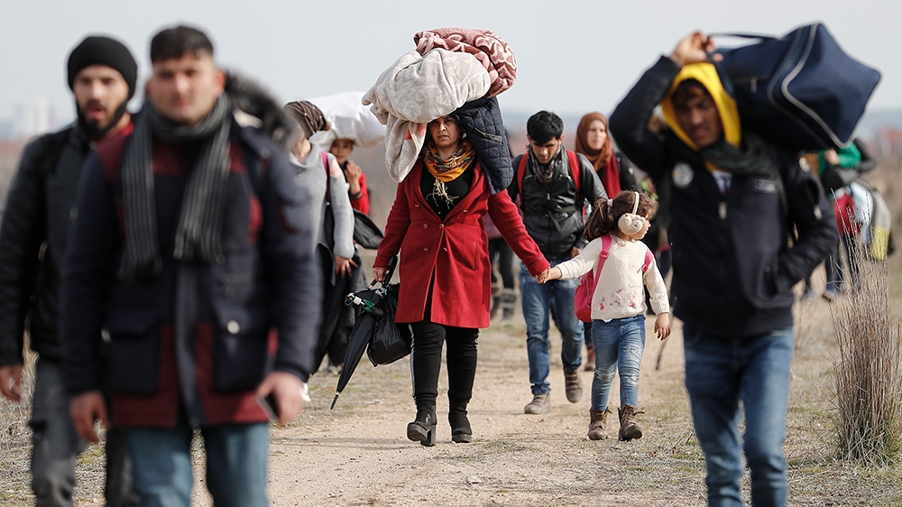 Refugees and migrants walk in a dirty road heading to the Turkish-Greek border and trying to enter Europe, in Edirne, Turkey, 01 March 2020. The Turkish government announced its decision to no longer 