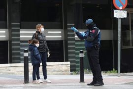A police officer talks to a woman outside a hotel that has been set up to treat non-critical coronavirus patients during the coronavirus disease (COVID-19) health emergency in Madrid, Spain, March 19,